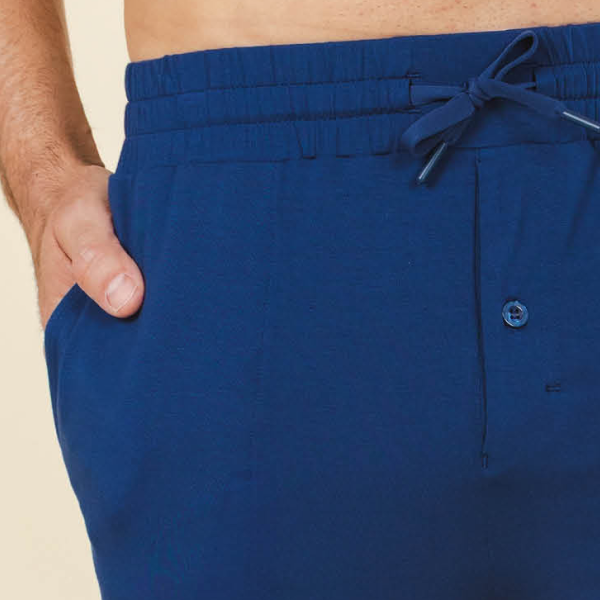 Pajama shorts in royal blue at the waist, drawcord tied in a bow above a button fly