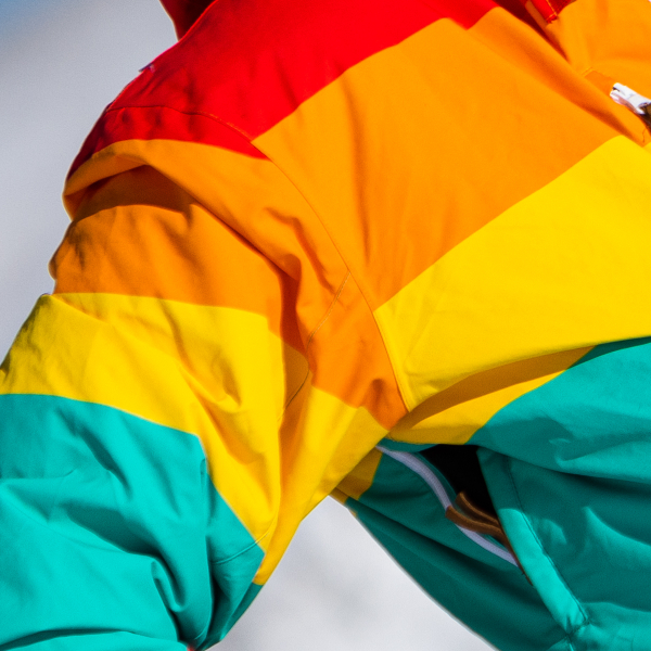 Red, orange, yellow and teal stripe panels of a retro Shinesty ski suit shell, seams and all