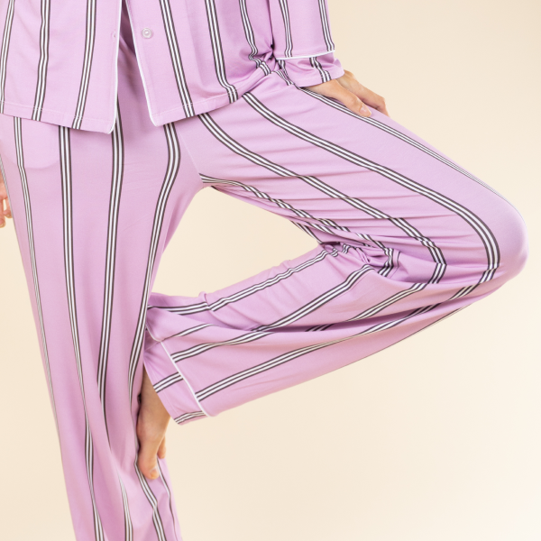Mid-stride with one knee bent in lavender striped Shinesty pajama pants trimmed in white piping
